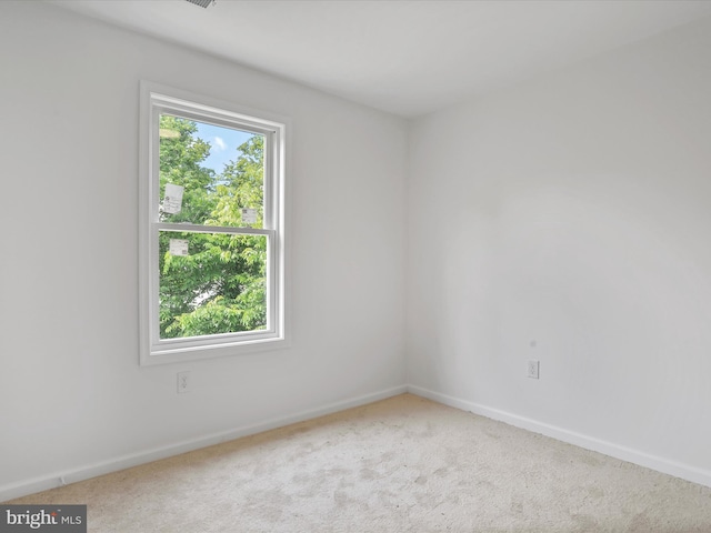 carpeted empty room featuring baseboards