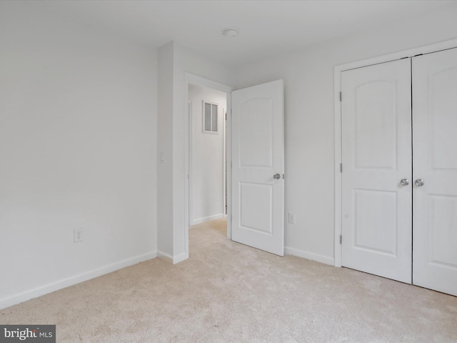 unfurnished bedroom featuring carpet floors, baseboards, and a closet