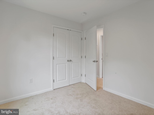 unfurnished bedroom with carpet, baseboards, and a closet