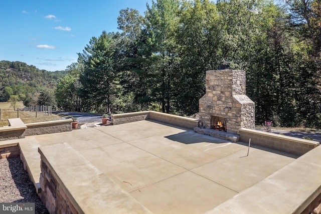 view of patio featuring an outdoor stone fireplace