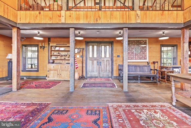 foyer entrance with wood walls and hardwood / wood-style flooring