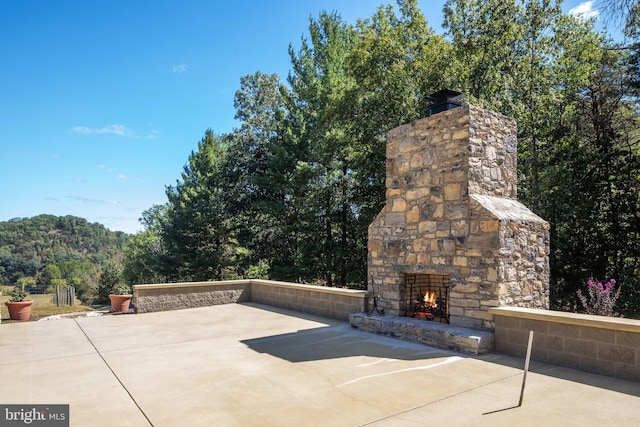 view of patio featuring an outdoor stone fireplace