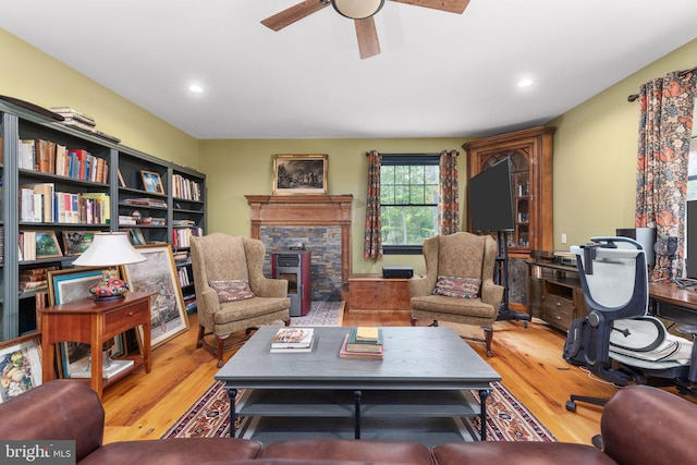 living room with a fireplace, hardwood / wood-style floors, and ceiling fan