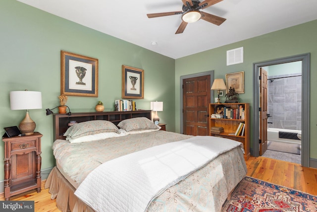 bedroom with ensuite bathroom, ceiling fan, and light hardwood / wood-style floors