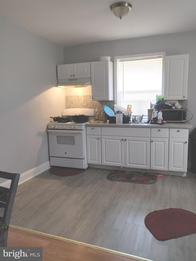 kitchen with backsplash, white cabinetry, and white range with gas stovetop