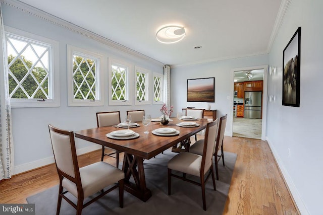 dining area with ceiling fan, crown molding, and light hardwood / wood-style flooring