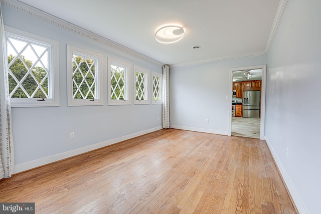 unfurnished room with ceiling fan, light wood-type flooring, and crown molding