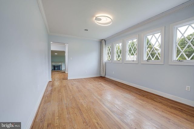 unfurnished room with light hardwood / wood-style floors and crown molding