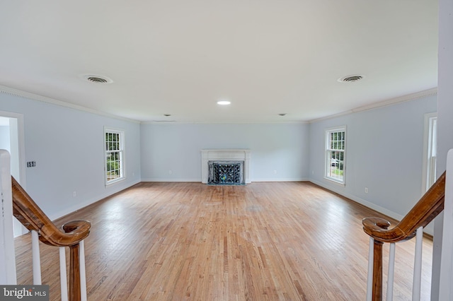 unfurnished living room featuring ornamental molding and light hardwood / wood-style floors