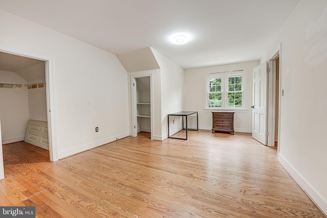 unfurnished bedroom with a spacious closet and light wood-type flooring