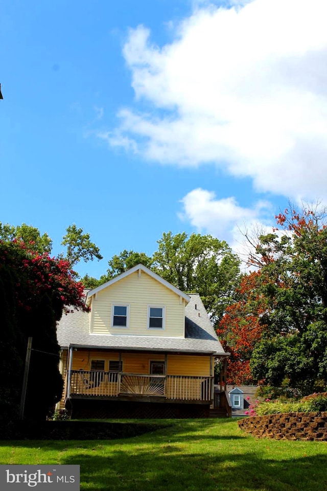 exterior space with a wooden deck and a front yard