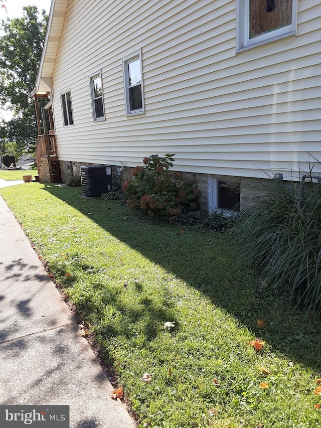 view of home's exterior with a lawn and cooling unit