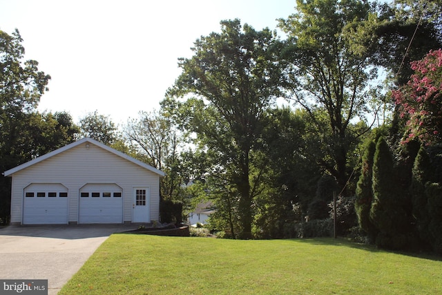 view of front of property featuring a garage, a front yard, and an outbuilding