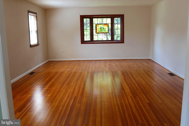 unfurnished room with hardwood / wood-style flooring