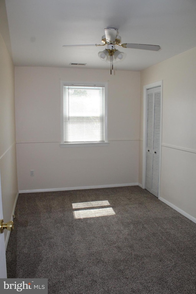 carpeted empty room featuring ceiling fan