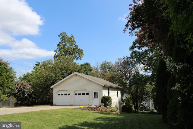 view of home's exterior featuring a garage, an outbuilding, and a lawn