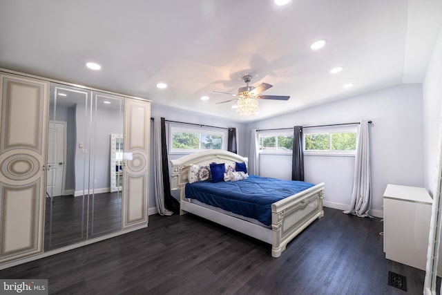 bedroom with vaulted ceiling, ceiling fan, dark hardwood / wood-style floors, and multiple windows