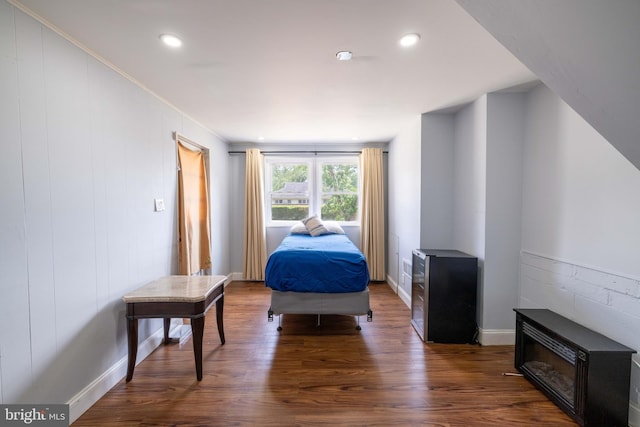 bedroom with a fireplace, dark wood-type flooring, and crown molding