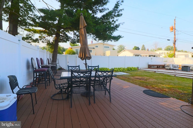 wooden terrace featuring a lawn