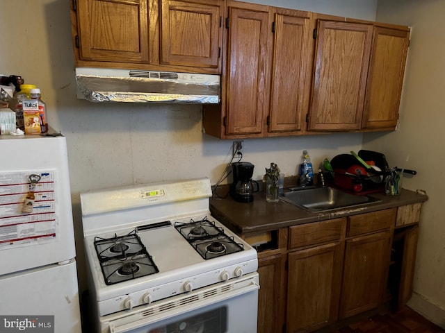 1717 W 4th St, Wilmington, DE 19805 - kitchen with white appliances, under cabinet range hood, brown cabinetry, and a sink