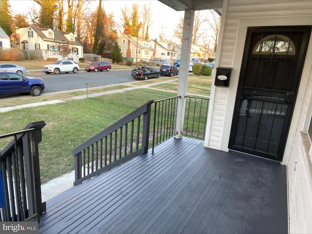 wooden deck with a yard and covered porch