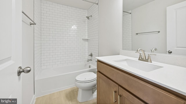 full bathroom featuring wood-type flooring, vanity, toilet, and tiled shower / bath combo