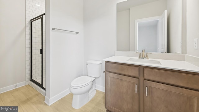 bathroom featuring vanity, toilet, and an enclosed shower