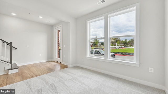 unfurnished living room with light carpet and a healthy amount of sunlight