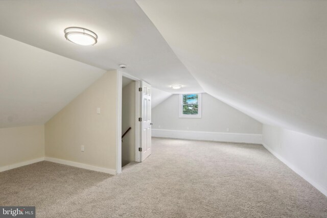 bonus room featuring light carpet and vaulted ceiling