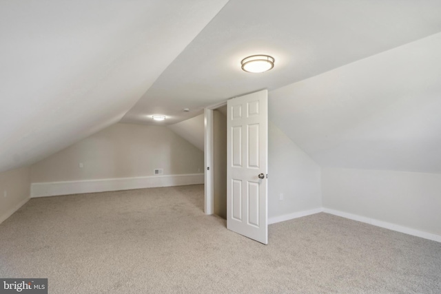 bonus room with light colored carpet and lofted ceiling