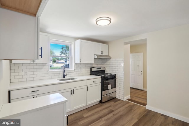 kitchen featuring stainless steel gas range oven, white cabinets, sink, dark hardwood / wood-style floors, and tasteful backsplash
