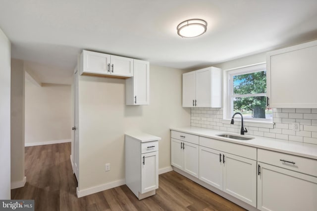 kitchen featuring decorative backsplash, white cabinetry, sink, and dark wood-type flooring