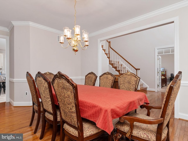 dining area featuring ornamental molding, a notable chandelier, and wood-type flooring