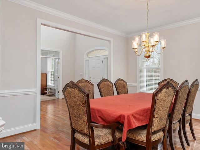 dining area with a chandelier, light hardwood / wood-style floors, and ornamental molding