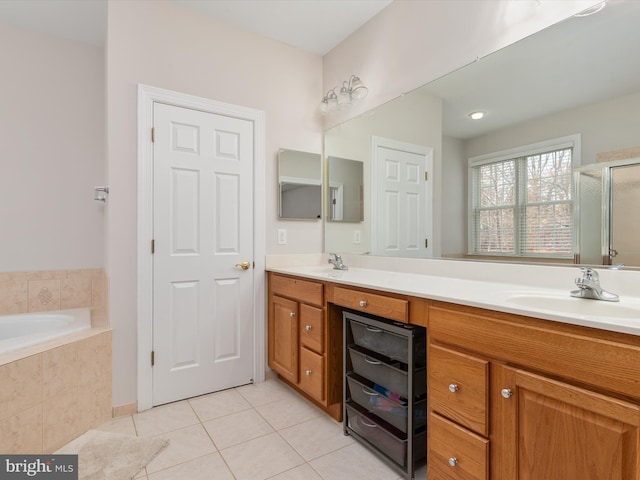 bathroom featuring plus walk in shower, vanity, and tile patterned floors