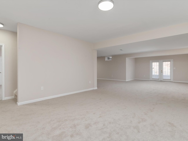 carpeted spare room featuring french doors