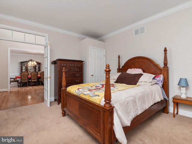 bedroom with a chandelier, crown molding, and light colored carpet