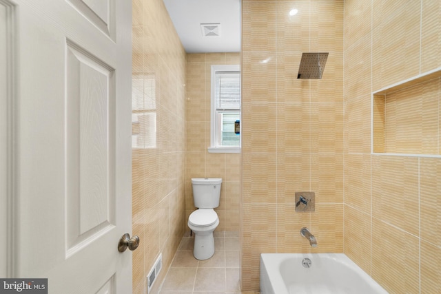 bathroom with tile walls, tile patterned floors, toilet, and shower / bath combination