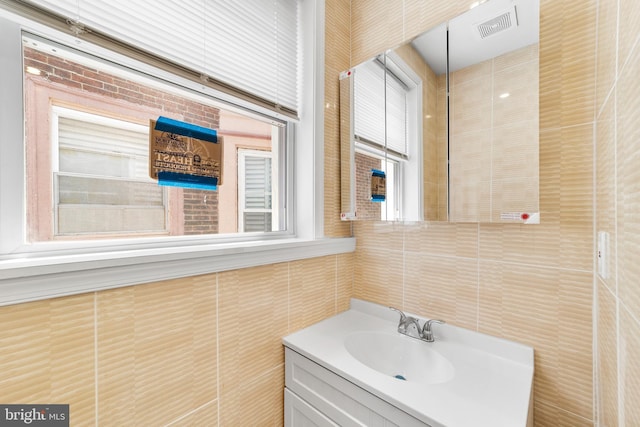 bathroom featuring vanity and tile walls