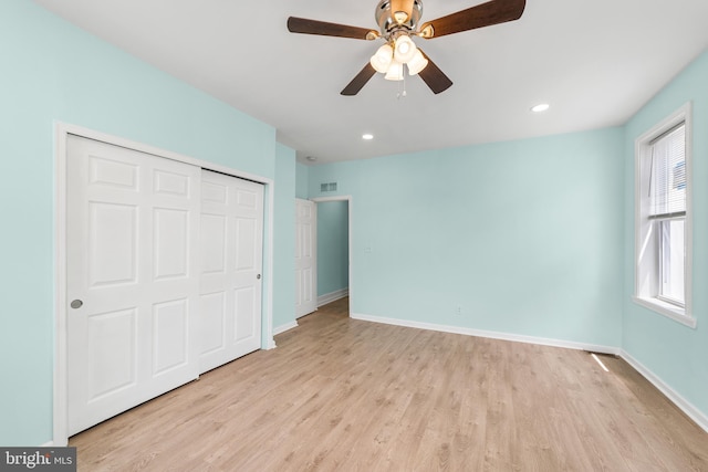 unfurnished bedroom featuring ceiling fan, light wood-type flooring, and a closet