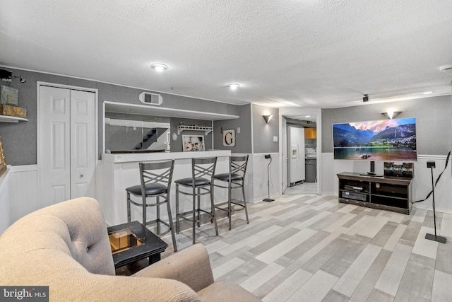 living room featuring bar area and a textured ceiling