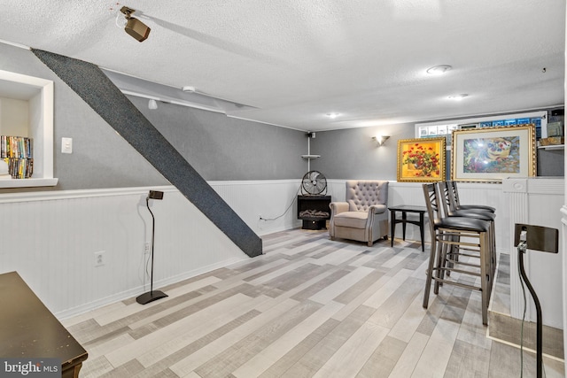 living area featuring a textured ceiling and light hardwood / wood-style floors