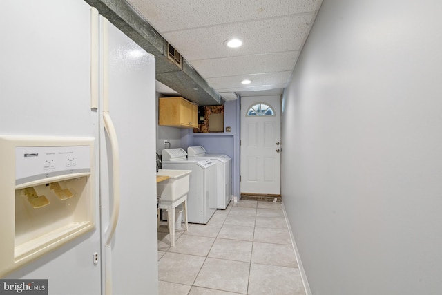 laundry room with light tile patterned floors, sink, independent washer and dryer, and cabinets