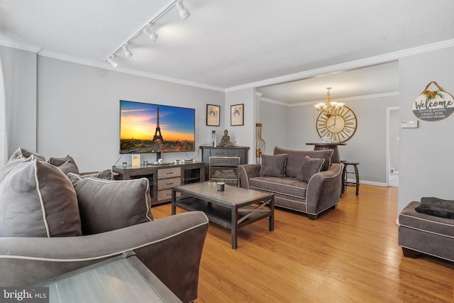 living room featuring a chandelier, crown molding, track lighting, and light hardwood / wood-style flooring