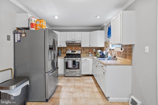 kitchen with decorative backsplash, sink, crown molding, stainless steel appliances, and white cabinets