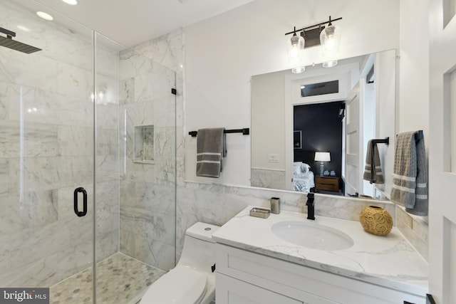 bathroom with toilet, tile walls, a shower with door, and vanity