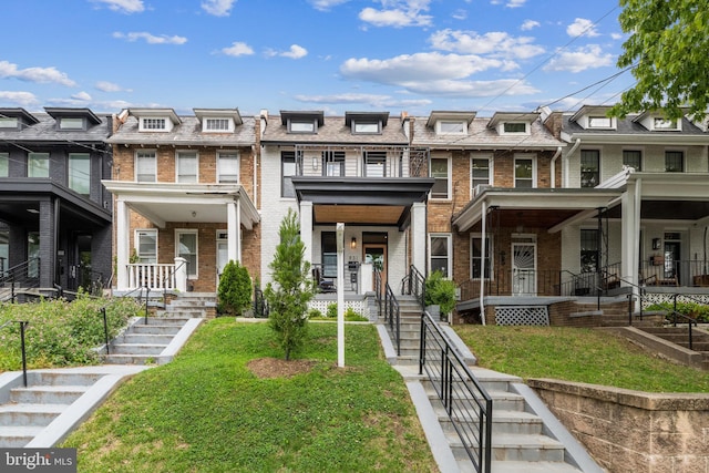 multi unit property featuring covered porch and a front yard