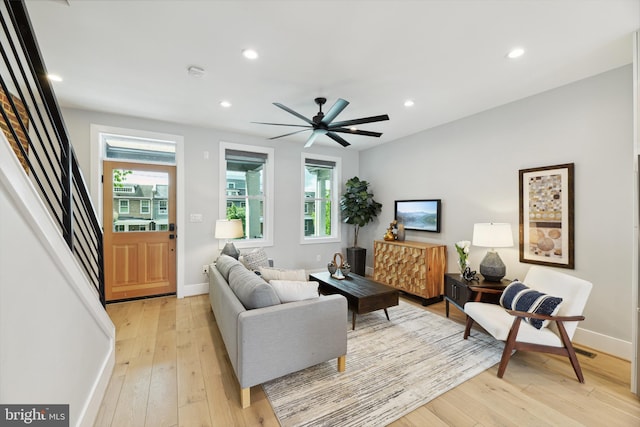 living room with ceiling fan, plenty of natural light, and light hardwood / wood-style flooring