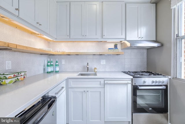 kitchen with gas range, sink, backsplash, and white cabinets