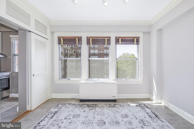 interior space with ornamental molding and radiator